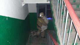 Пожарный выносит на руках жителя дома