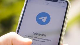 Telegram на экране телефона в руках