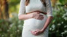 Беременная женщина в белом платье