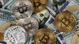 Монеты криптовалюты лежат на долларах