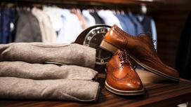 Мужская обувь и одежда выложены на витрине магазина