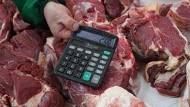Продавец мяса показывает на калькуляторе конечную цену