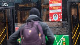 Мужчина с рюкзаком стоит возле автобуса
