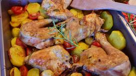 Куски курицы на противне с картофелем, кабачками и томатами