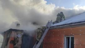 Пожарные поднимаются на крышу дома