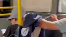 Мужчина закинул руку на спинку сиденья в автобусе