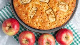 На столе яблоки и пирог в форме