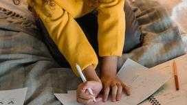 Девочка пишет в тетради