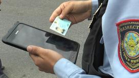 Полицейский проверяет удостоверение через планшет