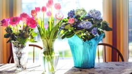 На столе вазы и кашпо с цветами