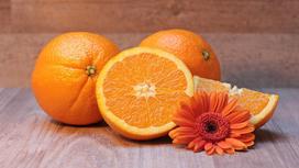 Апельсины и цветок на столе