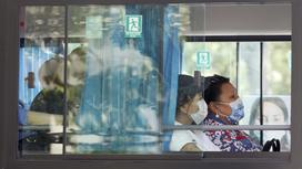 Две женщины едут в автобусе, вид из окна