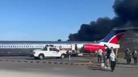 Люди бегут от горящего самолета