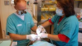 Стоматолог и медсестра проводят операцию
