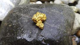 Самородок золота лежит на камне