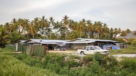 Дома и машина на фоне пальм в Таиланде