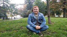 Руслан Лазута сидит на траве
