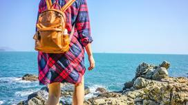 девушка с рюкзаком на пляже