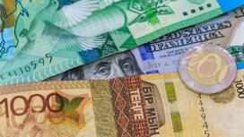Доллар США лежит под купюрами тенге