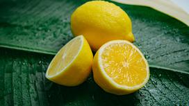 Разрезанный и целый лимон лежат на листе