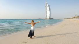 Девушка идет по пляжу в Дубае