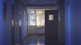 Темный коридор больницы с открытой дверью