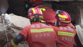 Спасатели в поисках выживших после обрушения здания