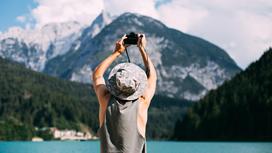 Мужчина фотографирует горы