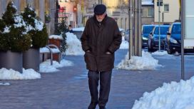 Пожилой мужчина идет по улице