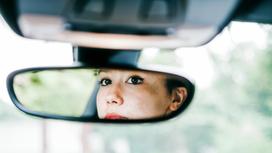 Девушка в отражении зеркала в автомобиле