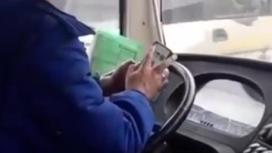 Водитель автобуса сидит в телефоне