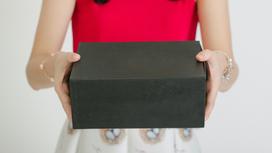 Девушка держит в руках черную коробку
