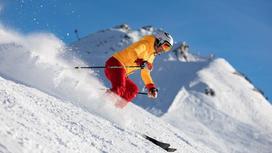 Женщина на лыжах спускается со склона