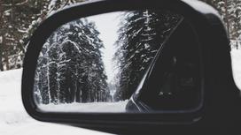 Боковое стекло автомобиля, который едет по дороге зимой