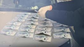 Полицейские пересчитывают изъятые деньги в ЗКО