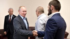 Владимир Путин жмет руку Хабибу Нурмагомедову