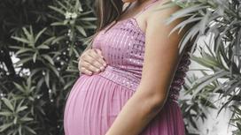 Беременная женщина в розовом платье