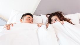 Пара в постели укрылась одеялом