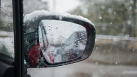 Снег на зеркале заднего вида автомобиля