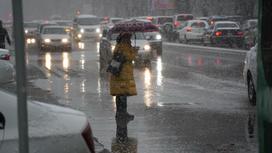 девушка с зонтом стоит под снегом на дороге