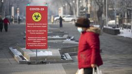 Женщина в маске идет по улице в Алматы