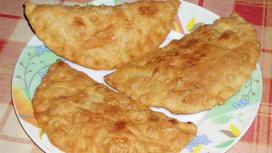 Чебуреки с мясом на тарелке на столе Чебуреки с мясом на тарелке на столе
