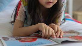 Маленькая девочка читает книжку