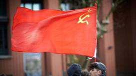 мужчин держит в руках флаг СССР