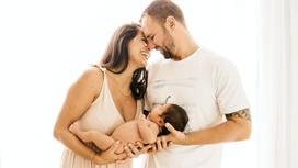 Мужчина и женщина держат новорожденного