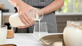 Человек наливает молоко из графина в стакан