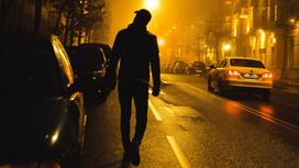 Мужчина идет по темной улице
