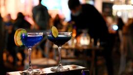 Два бокала с коктейлем стоят на барной стойке