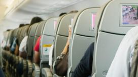 Пассажиры сидят в креслах в самолете