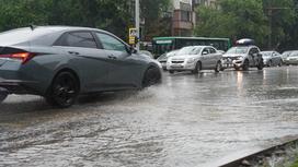 Машины едут по затопленной дождем дороге